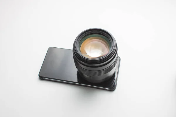 Primo piano di un obiettivo della fotocamera su un telefono cellulare in un backgroun bianco — Foto Stock