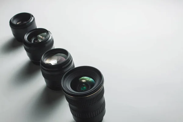 Vista de primer plano de un grupo de lentes de cámara sobre una superficie blanca —  Fotos de Stock