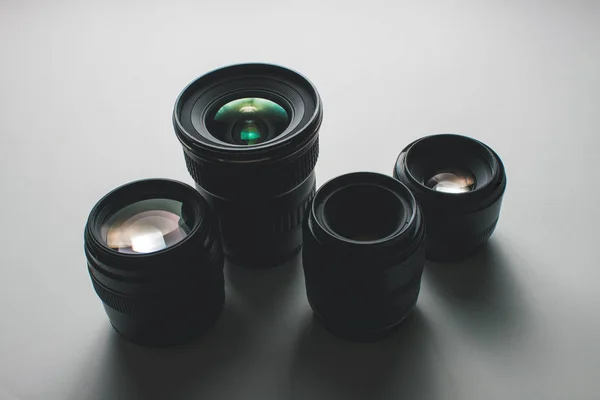 Visão de perto de um grupo de lentes de câmera em uma superfície branca — Fotografia de Stock