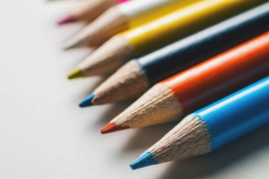 Bir grup beyaz bir yüzeye çok renkli kalemler Close-Up