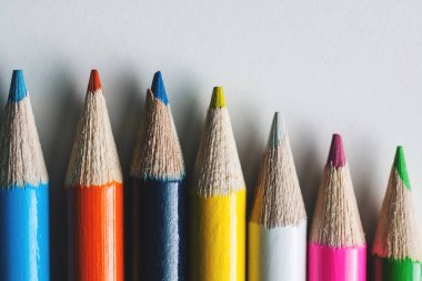 Bir grup beyaz bir yüzeye çok renkli kalemler Close-Up