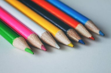 Bir grup beyaz bir yüzeye çok renkli kalemler Close-Up