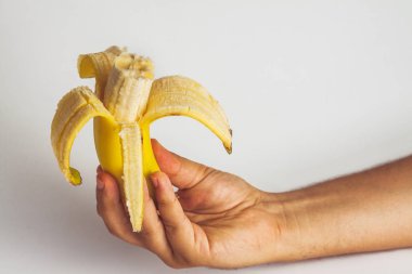 el bir soyulmuş muz beyaz bir arka plan üzerinde tutarak