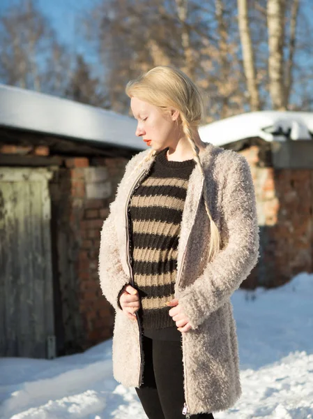 Mladá blondýnka v šedé pruhovaný svetr a úplet bílý plášť v zimě — Stock fotografie