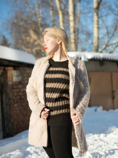 Mladá blondýnka v šedé pruhovaný svetr a úplet bílý plášť v zimě — Stock fotografie