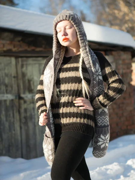 Mladá blondýnka v šedé pruhovaný svetr a čepice s dlouhé uši v zimě — Stock fotografie