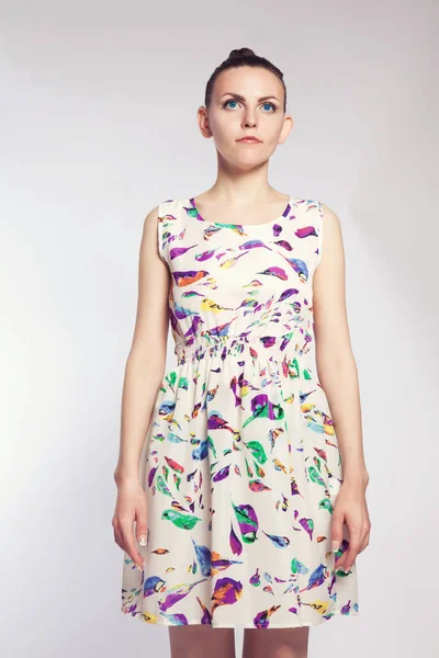 Menina jovem em vestido branco com um padrão na forma de pássaros brilhantes — Fotografia de Stock
