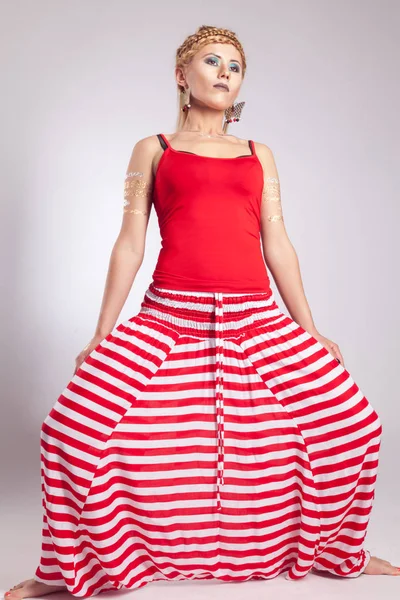 Chica joven en pantalones étnicos a rayas rojas y blancas —  Fotos de Stock