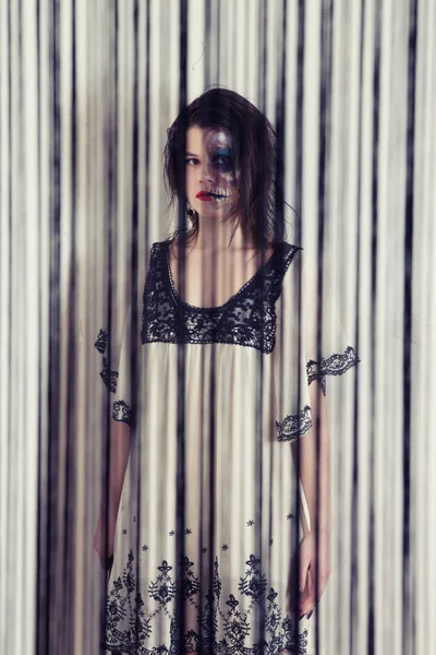 Dívka s neobvyklý make-up v černé a bílé šaty se sekyrou v podobě šílený vrah — Stock fotografie