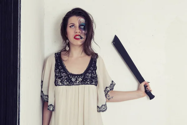 Κορίτσι με ένα ασυνήθιστο μακιγιάζ σε ένα μαύρο και άσπρο φόρεμα με ένα τσεκούρι με τη μορφή μιας τρελής δολοφόνος — Φωτογραφία Αρχείου