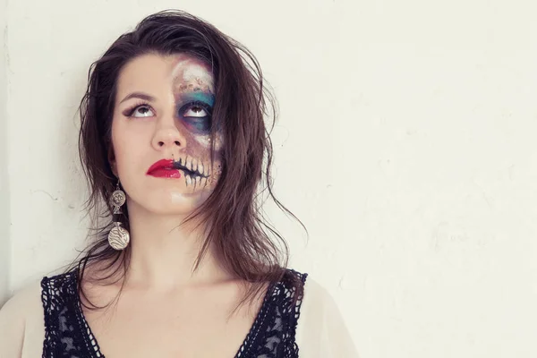 Girl with an unusual make-up in a black and white dress with an ax in the form of a mad assassin — Stock Photo, Image