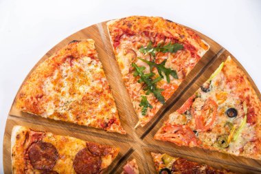 Ahşap bir tepside farklı dolguları ile çeşitli pizza