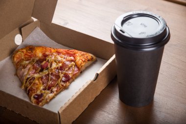 bir parça pizza bireysel bir karton kutu ve kahve için plastik bir kap içinde