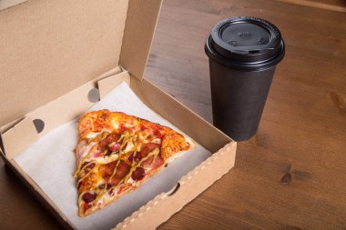 bir parça pizza bireysel bir karton kutu ve kahve için plastik bir kap içinde