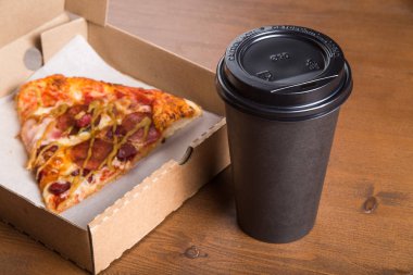 bir parça pizza bireysel bir karton kutu ve kahve için plastik bir kap içinde