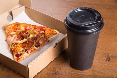 bir parça pizza bireysel bir karton kutu ve kahve için plastik bir kap içinde