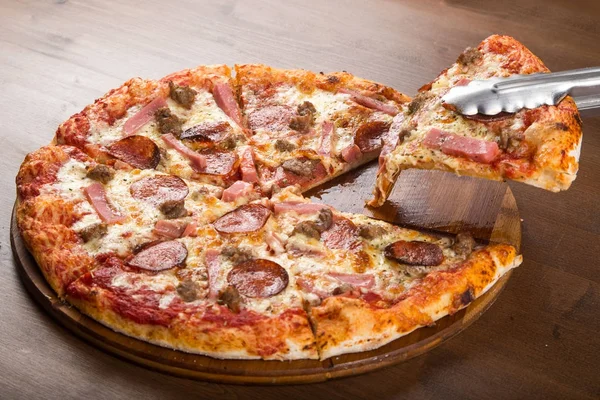 Tăiat în bucăți de cârnați de pizza, salam și brânză pe un platou din lemn — Fotografie, imagine de stoc