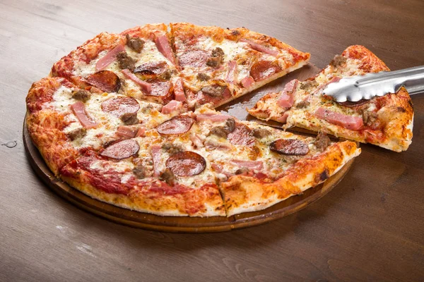 Tăiat în bucăți de cârnați de pizza, salam și brânză pe un platou din lemn — Fotografie, imagine de stoc