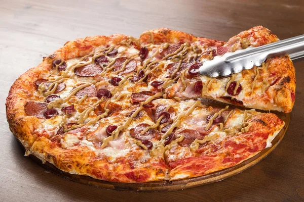 Cortado em pedaços de salsicha de pizza, salame e queijo em uma bandeja de madeira — Fotografia de Stock