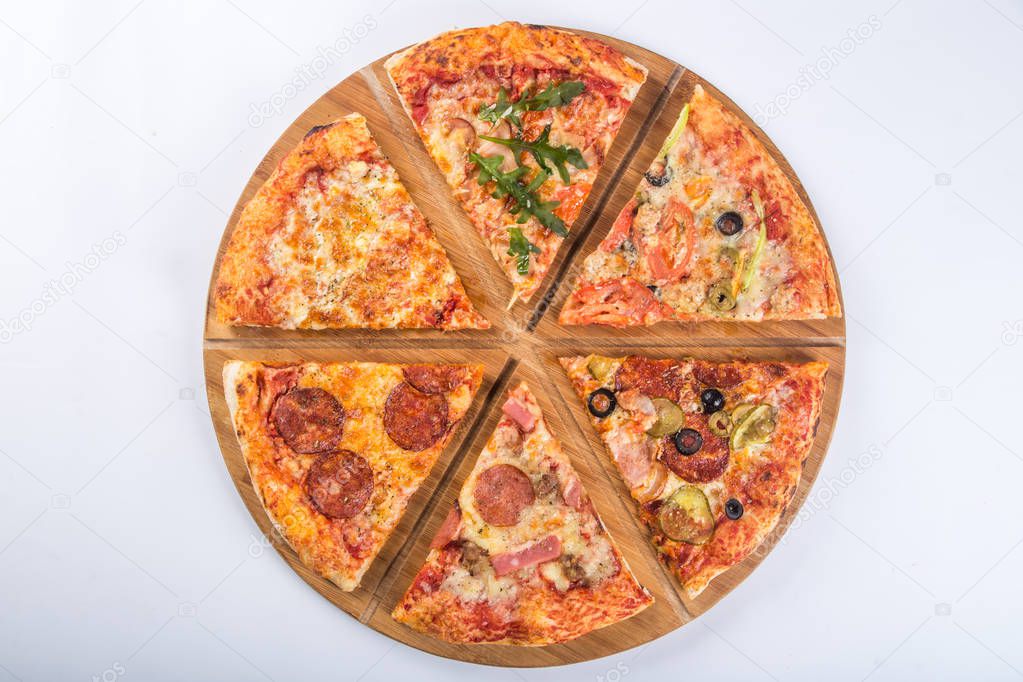 Assorted pizza with different fillings on a wooden platter