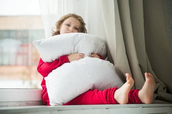 雪の白の枕と赤いパジャマの女の子 — ストック写真