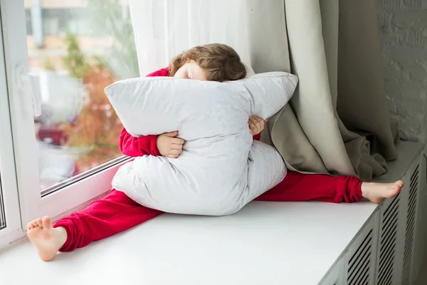 Menina de pijama vermelho com um travesseiro branco de neve — Fotografia de Stock