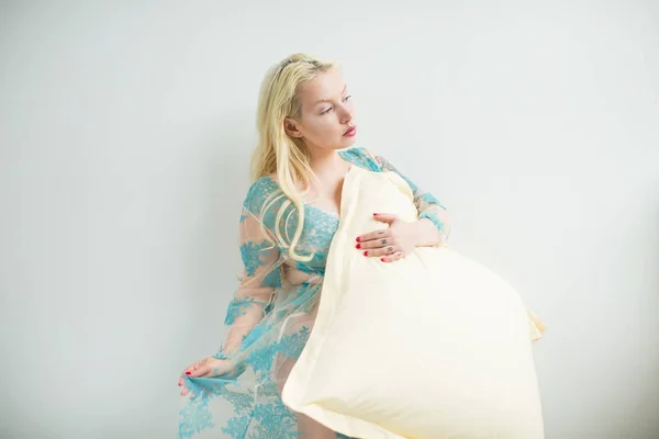 Blonde dans une robe transparente avec un motif bleu s'assoit sur le lit — Photo