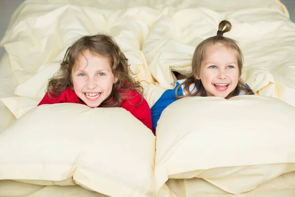 ベッドに赤いパジャマで少女と青いパジャマうその少年を笑ってください。 — ストック写真