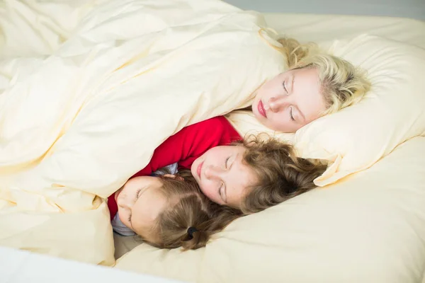 Сім'я лежить під ковдрою в ліжку — стокове фото