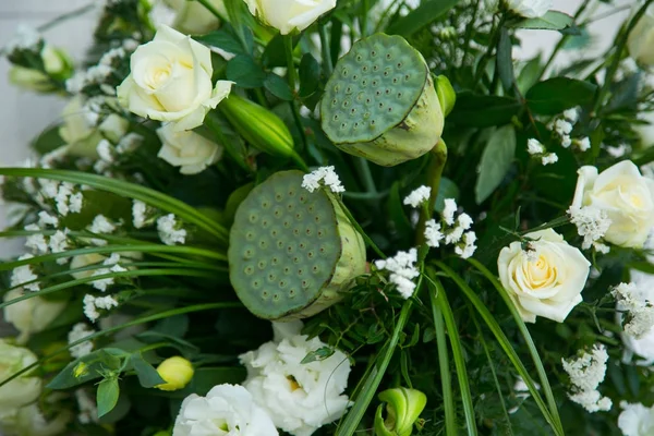 Bukett av vita rosor, gula påskliljor, grönska och lotusblommor — Stockfoto