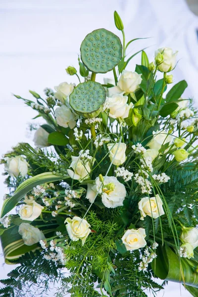 Bukett av vita rosor, gula påskliljor, grönska och lotusblommor — Stockfoto