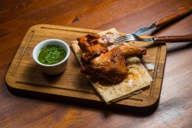 ahşap bir tepside soslu kızarmış tavuk parçaları