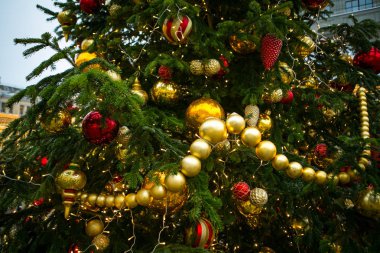 Altın ve kırmızı top, boncuk ve tinsel ile süslenen yılbaşı ağacı,