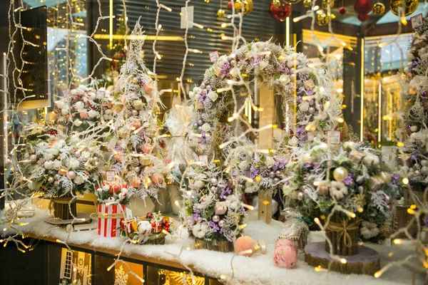 圣诞节花圈和花束在商店窗口 免版税图库图片
