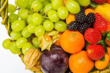 sepet meyve ve çilek, parlak çiçeklerle dekore edilmiş ve