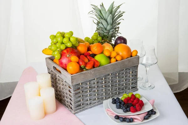 Natürmort: sepet meyve ve çilek, mumlar ve bir kadeh şarap ile