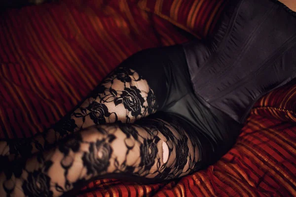 女性膝在黑丝袜在网格 图库照片