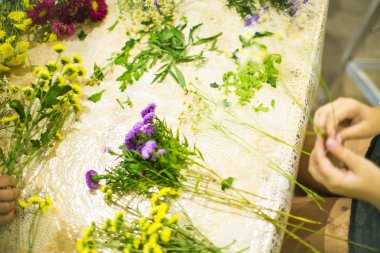 Buket için kompozisyon: çiçekler, kurdeleler, çim