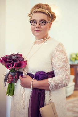 Gelin beyaz elbiseli ve düğün buketli