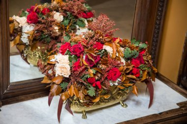 Beyaz, pembe ve güller dallar ayak üzerinde bir antika vazo içinde bir buket