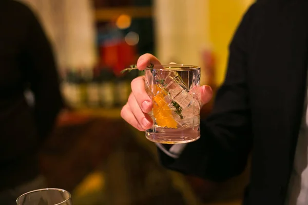 bir bardak viski elini tutar