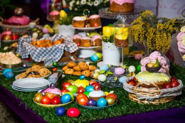 Hasır sepetleri ve çörekler çok renkli yumurta