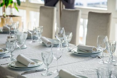 Çatal bıçak takımı ve gözlük bir beyaz masa örtüsü ile kaplı uzun bir masa