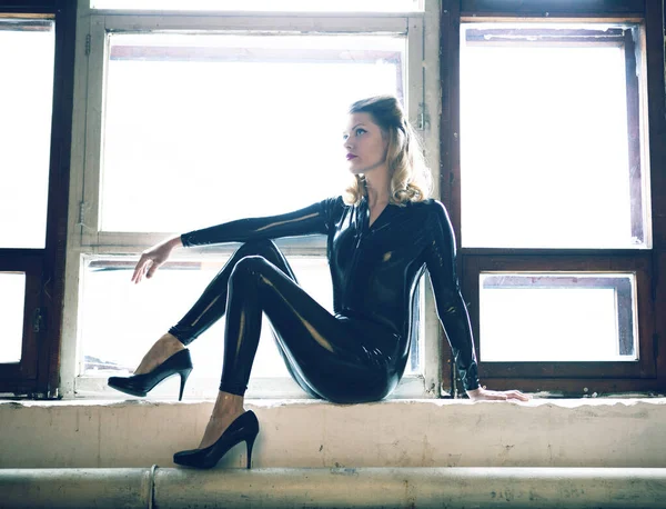 Blonde Black Latex Suit Sits Windowsill Sexy Pose — Stock Photo, Image