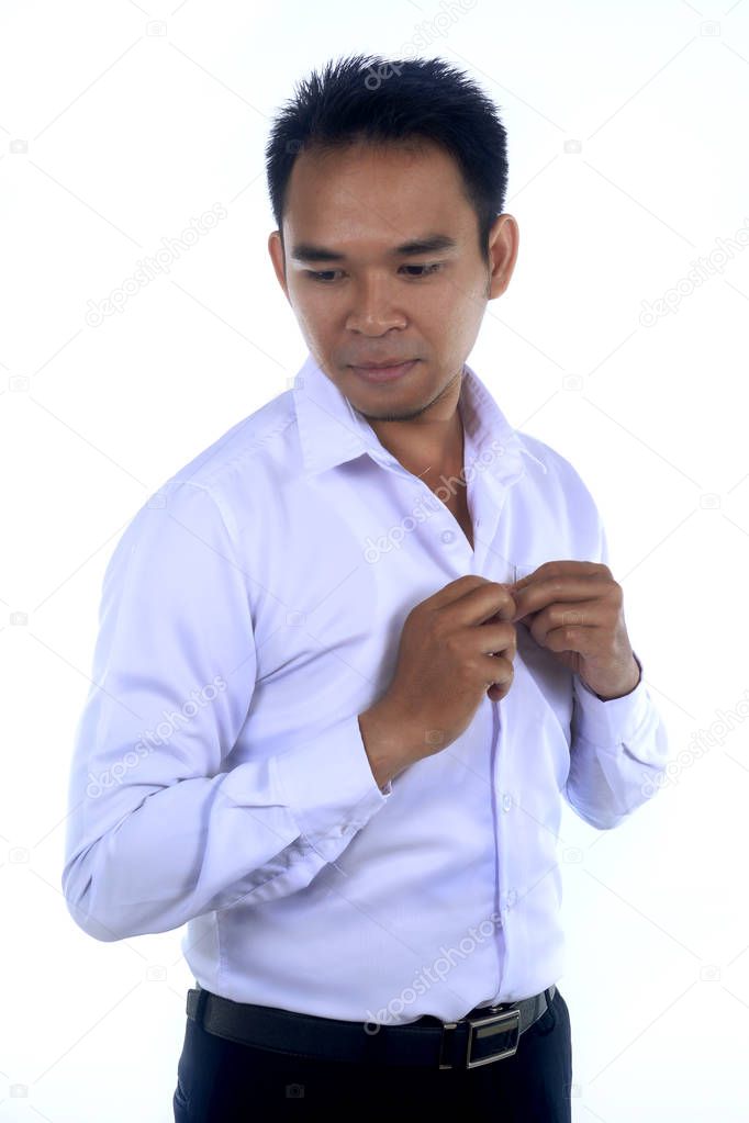 Photo image of a handsome attractive young Asian businessman dressing, button up his shirt. Ready to work in formal wear