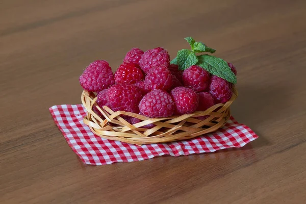 Frambuesas frescas maduras en una pequeña canasta —  Fotos de Stock