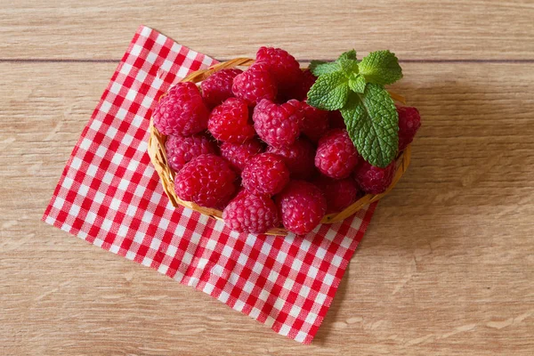 Framboesas maduras frescas em uma pequena cesta — Fotografia de Stock