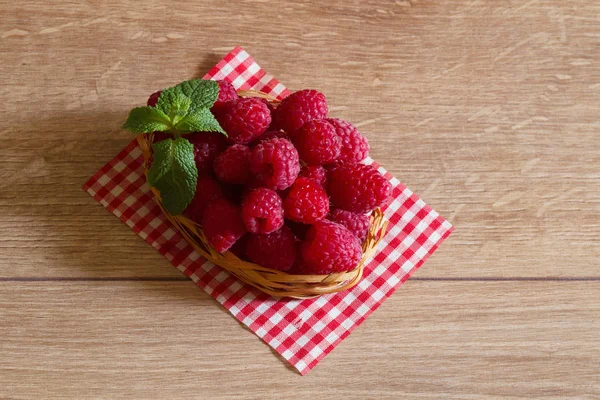 Frische reife Himbeeren in einem kleinen Korb — Stockfoto