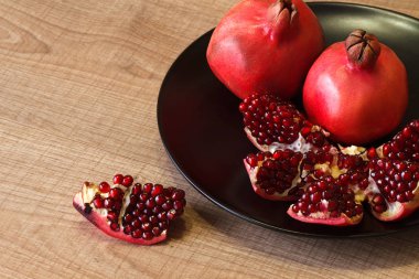 Olgun Azeri nar siyah plaka ve ahşap bir masa