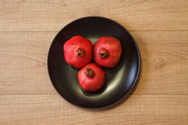 Olgun Azeri nar siyah plaka ve ahşap bir masa